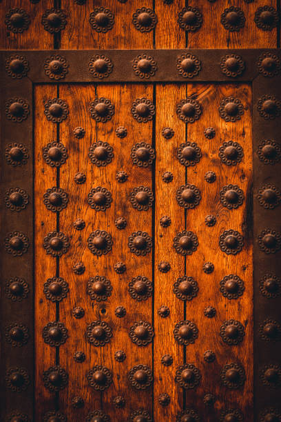 istock Wooden entrance door with iron studs pattern. 1348756223