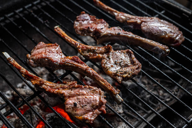 istock Grilled lamb mutton chop steaks on barbecue, outdoor BBQ grill with fire. Top view 1348756311