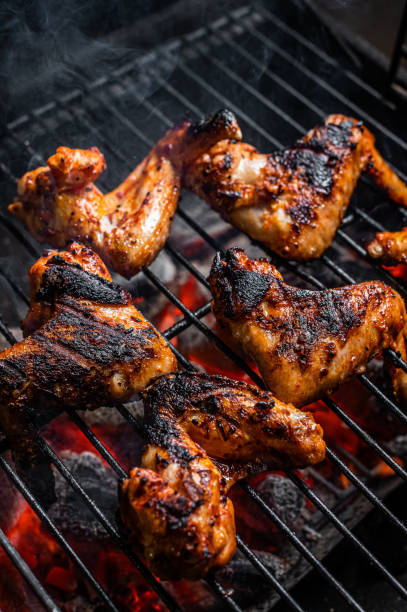 istock Chicken wings on barbecue, outdoor BBQ grill with fire. Top view 1348756601