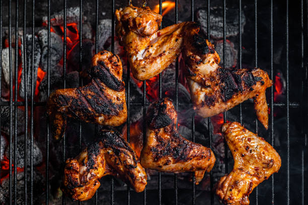 istock Chicken wings on barbecue, outdoor BBQ grill with fire. Top view 1348757056