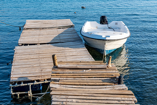 A boat tied to a ramshackle wooden pier.