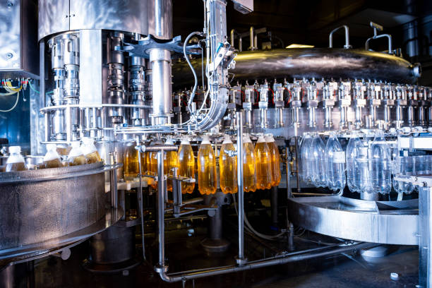 istock Automatic filling machine pours water into plastic PET bottles at modern beverage plant. 1348765094