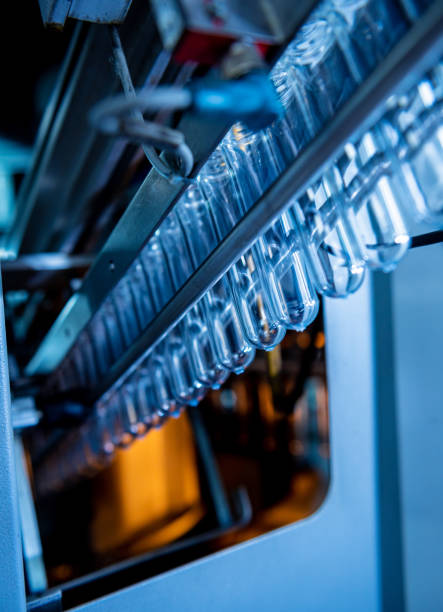istock Automatic filling machine pours water into plastic PET bottles at modern beverage plant. 1348765863