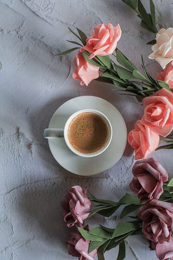 Coffee cup with rose flower on white table background. Valentine day with place for text. Vintage photo. Space for text