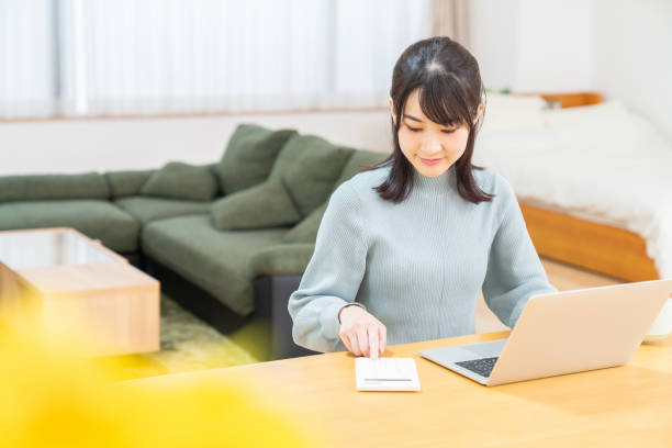 young asian woman using laptop,calculator