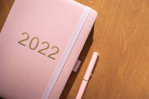 istock Pink coral colored diary for the year 2022, pen, coffee 1348797644