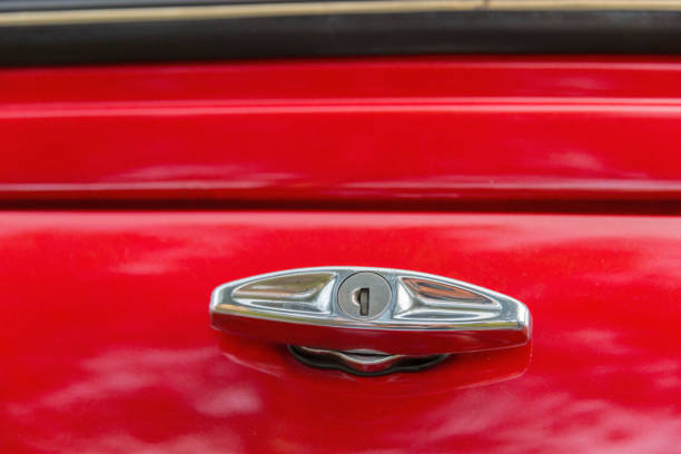 Close up of a handle for opening the tailgate of a vintage red car