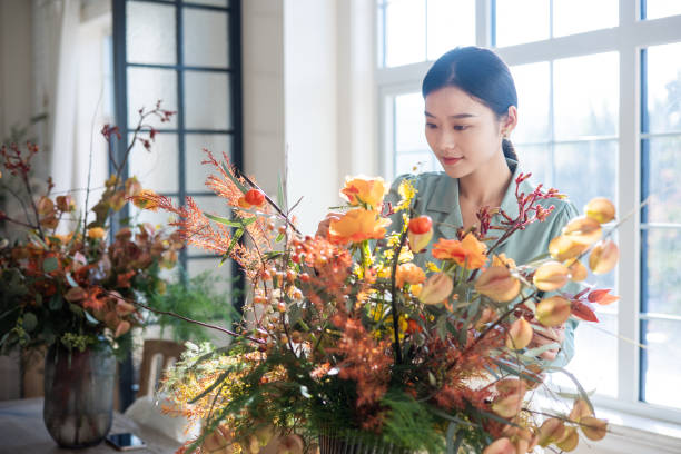 istock Woman arranging flowers at home 1348828152