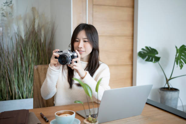 istock Female freelancer checking picture previews on her camera. 1348828534