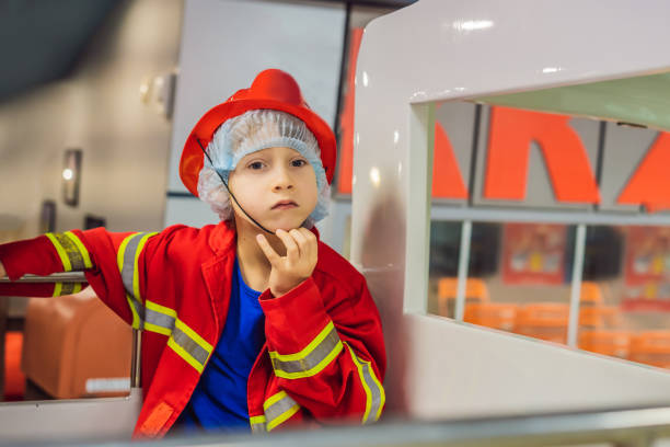 istock Expressive cute toddler with fireman's outfit playing fireman 1348829728