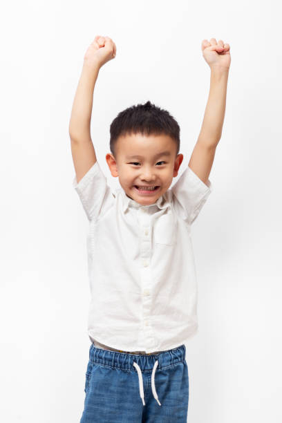 istock Happy kid putting hands up with big smile on white background 1348830589
