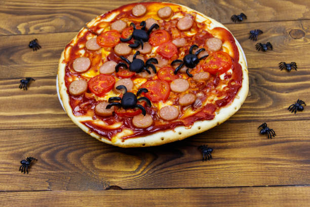 istock Halloween pizza with spiders on wooden table 1348830684