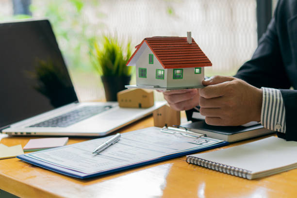 istock Businessman or home sales representative working in the office with contract documents and calculator with a laptop. to calculate interest, taxes and to advise customers on buying and renting 1348830691