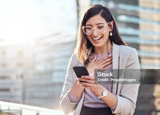 Shot Of An Attractive Young Businesswoman Standing Alone Outside And Looking Surprised While Using Her Cellphone Stock Photo - Download Image Now