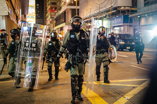 HongKong - December 01, 2019: Riot Police clearing street at night during the 2019  protests, a series of demonstrations in Hongkong started as the Anti-Extradition Law Amendment Bill (Anti-ELAB) movement.