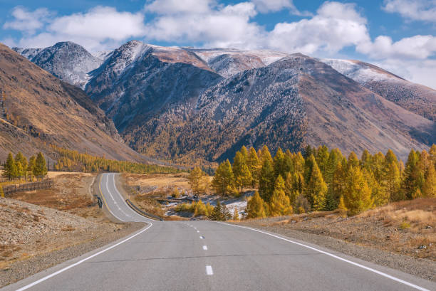 istock road mountains asphalt snow autumn forest clouds 1348831679