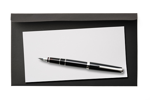 Opened black paper envelope and blank note with fountain pen, isolated on white with clipping path.