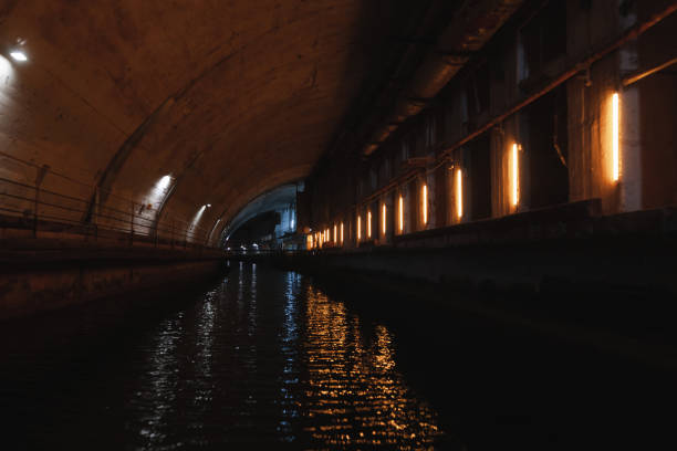 Narrow alley with puddles reflecting lights at night
