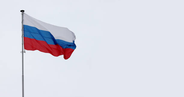 istock Russia flag on gray cloudy sky. 1348836679