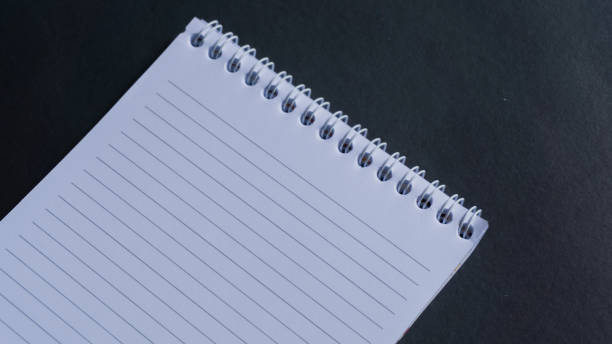 istock minimal work space, top view of note book on black background. note book copy space and text space 1348837671