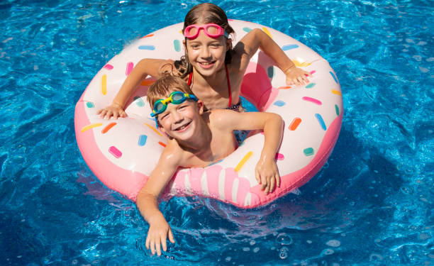 istock boy and girl in swimming pool 1348840125