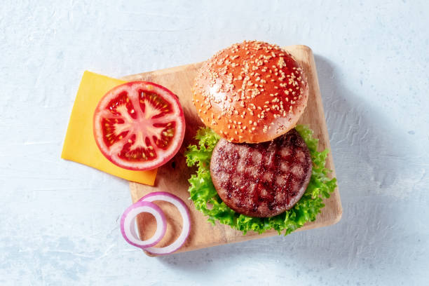 burger ingredients, shot from above on a wooden board. hamburger beef patty - sesame bun american culture cheddar imagens e fotografias de stock