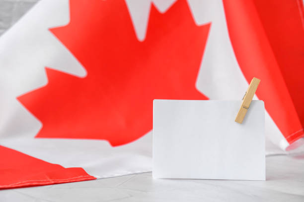 istock The National Flag of Canada. Canadian Flag or the Maple Leaf with empty paper note Copy space. Tourist traveler or patriotism. International relations concept. Independence day 1348842141