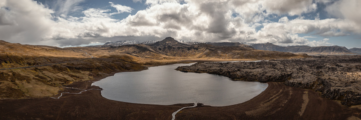 Volcanic Lake Selvallavatn surrounded with volcanic lava field. Lake Selvallavatn is located 62 m above sea level. River Fossa enters it from the east and a few small brooks from the south. Aerial Drone Point of view stiched XXL Panorama. Berserkjahraun Lava Field and Snæfellsnes Mountain Range in the background. Lake Selvallavatn, Snæfellsnes, Vesturland, Iceland, Nordic Countries, Europe