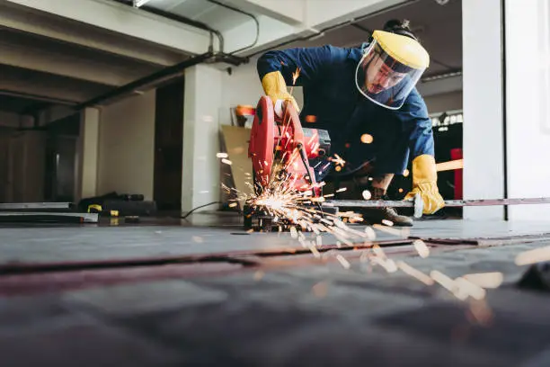 Craftsman Welding is Cutting Steel Work in Fabrication Workshop, Welder Man in Safety Protective Equipments Doing Metalwork in Construction Site. Steel Labor Skill and Workshops Production Concept