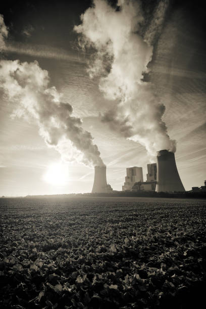 pollution spilling into the sky from a modern coal fired power plant - sepia image imagens e fotografias de stock