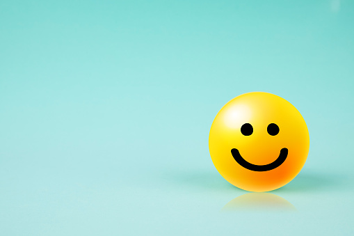 Happy smiley face emoticon with copy space on blue background