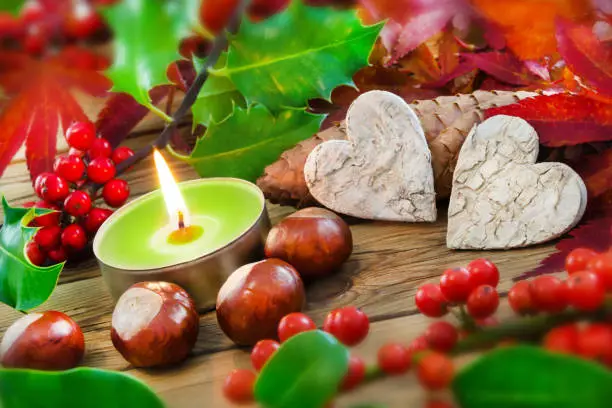 Natural Autumn decoration and burning candle with two hearts