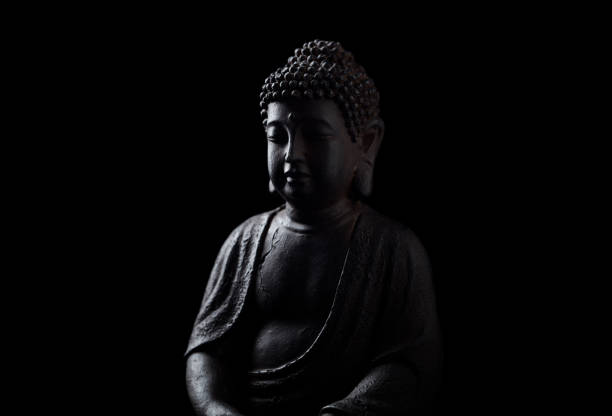 istock Meditating Buddha Statue isolated on black background. Copy space. 1348846074