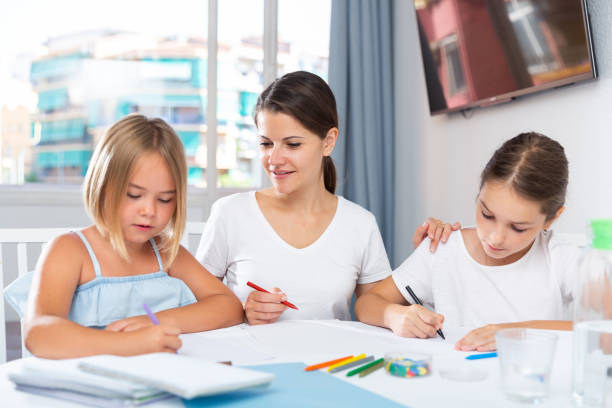 istock Young woman and two daughters drawing together 1348847221