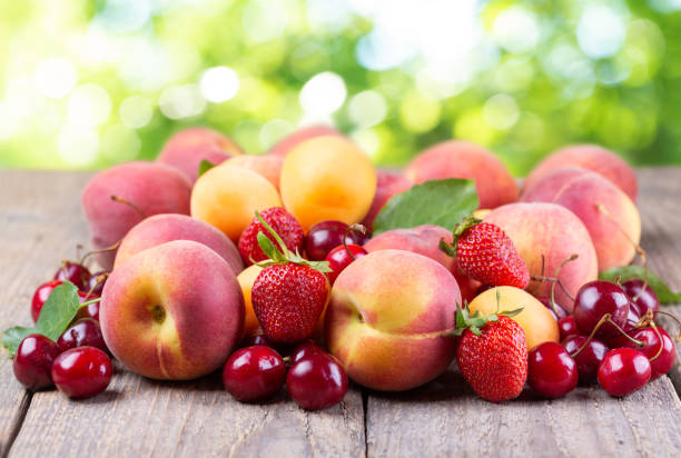 istock fresh fruits on a wooden table on green background 1348848694