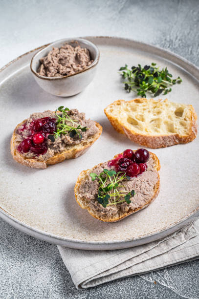 istock Toasts with chicken rillettes pate on white bread with sprouts. White background. Top View 1348850306