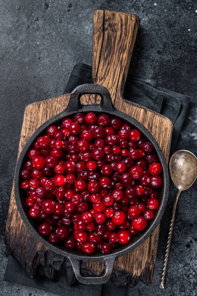 istock Red fresh Cranberry berry in a pan. Black background. Top view 1348851611