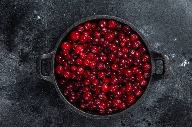 istock Red fresh Cranberry berry in a pan. Black background. Top view 1348851622