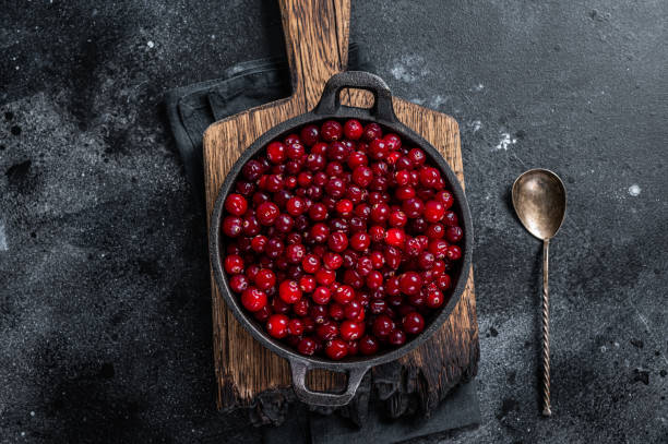istock Red fresh Cranberry berry in a pan. Black background. Top view 1348851632