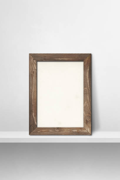 istock Wooden picture frame leaning on a white shelf. 3d illustration. Vertical background 1348852061
