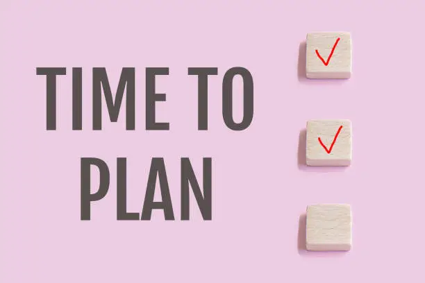 Photo of Wooden blocks with check mark on pink background