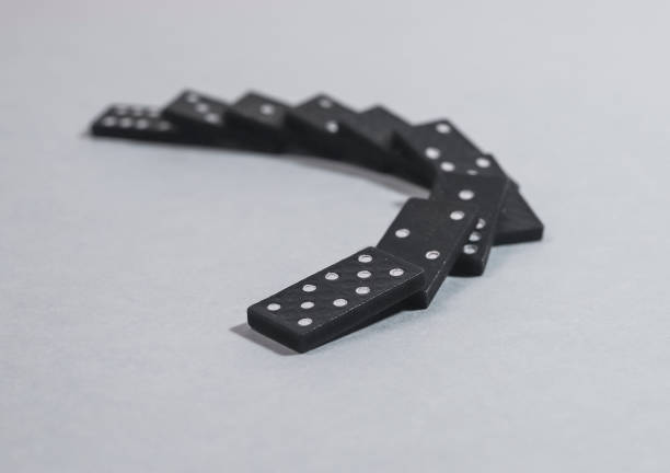 istock Domino game pieces falling on each other on gray blue backgound 1348853862