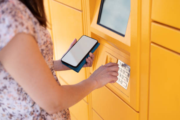 istock Woman using mobile smart phone in front of ATM or terminal 1348854550