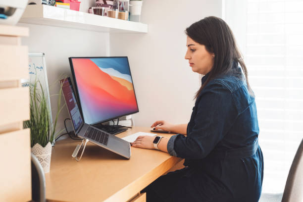 istock Caucasian woman working on two screens 1348855257