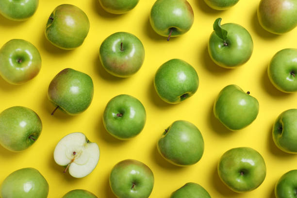 istock Tasty green apples on yellow background, flat lay 1348855350