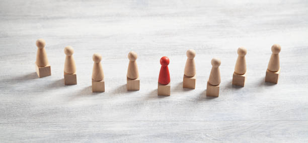 istock Wooden human figures on the white desk. Leader 1348855498