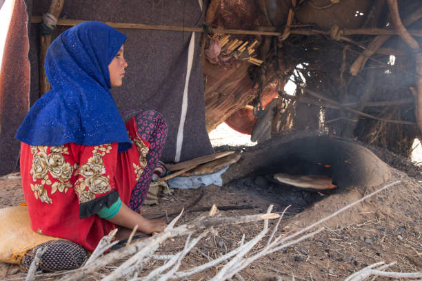 Girl bakes bread in a traditional oven in the Sahara desert Girl bakes bread in a traditional oven in the Sahara desert, Morocco moroccan girl stock pictures, royalty-free photos & images