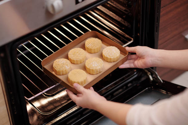 istock Woman Putting Mooncakes in Oven 1348858284