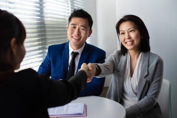 asian business partners shake hands with female financial consultant after successful business deal in the meeting room. - cheering business three people teamwork imagens e fotografias de stock