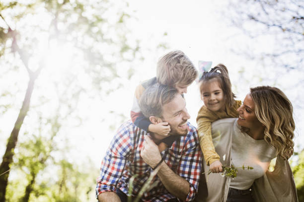 istock Playful family having fun while piggybacking in nature. 1348860198